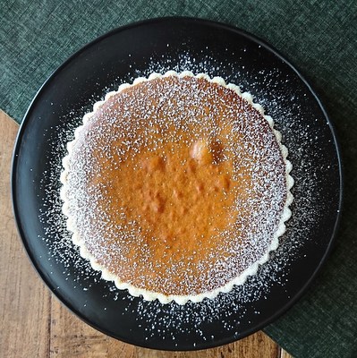 黒の丸皿に乗ったパンプキンパイ。