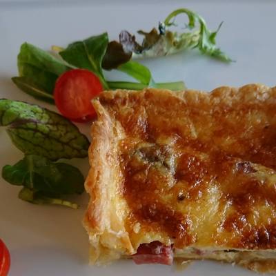 白いお皿の上にキッシュとグリーンサラダが盛り付けてあります。