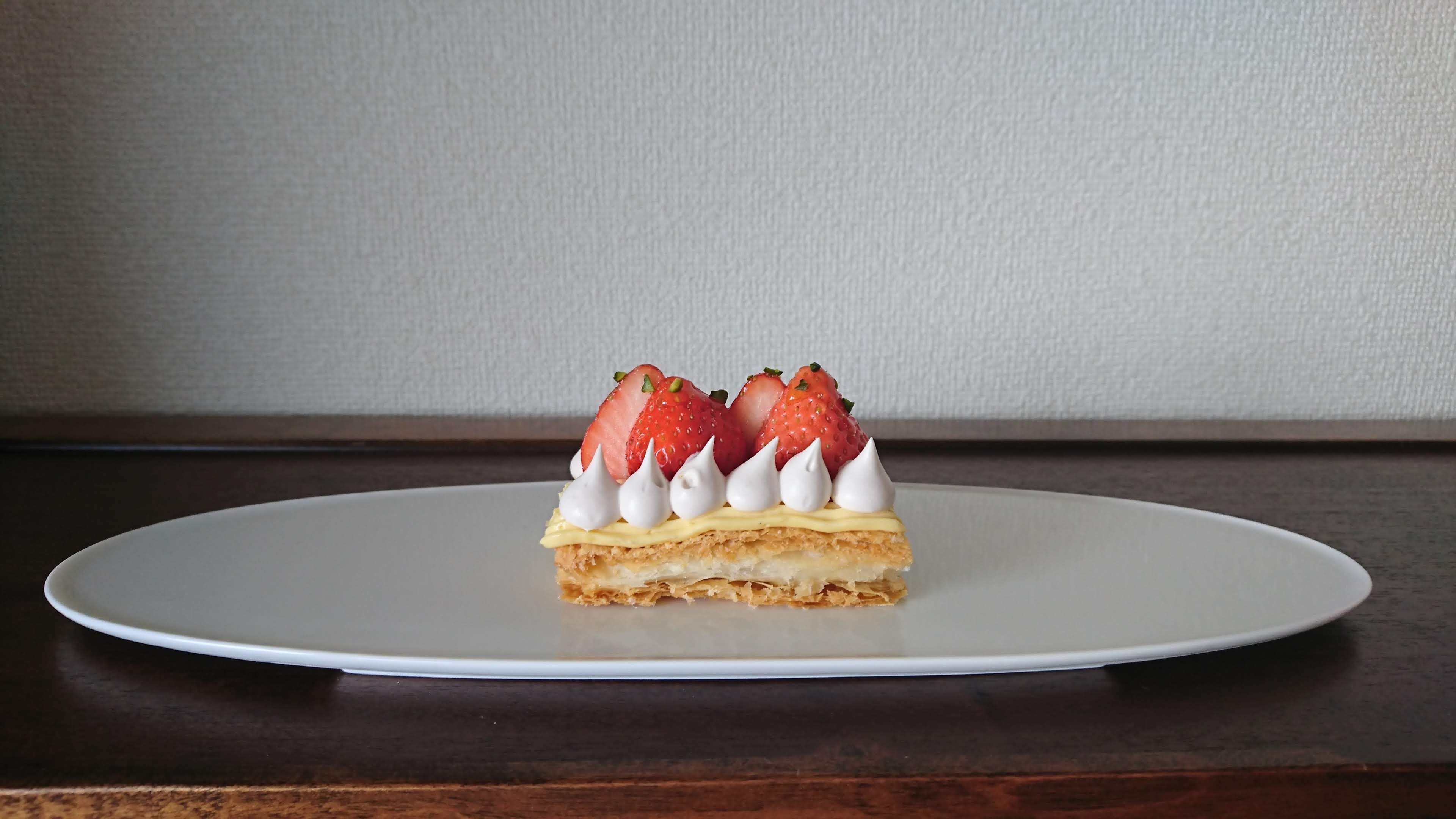 白のお皿に苺とクリームがのったパイ菓子