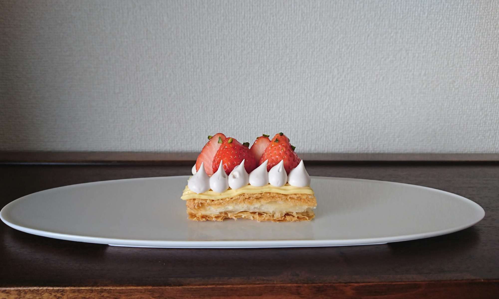 白のお皿に苺とクリームがのったパイ菓子