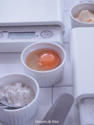 デジタル計量器や卵、粉、バターが並んでいます。