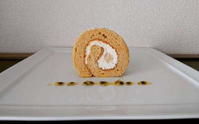 白いお皿にカットされたロールケーキとソースが並んでいます。