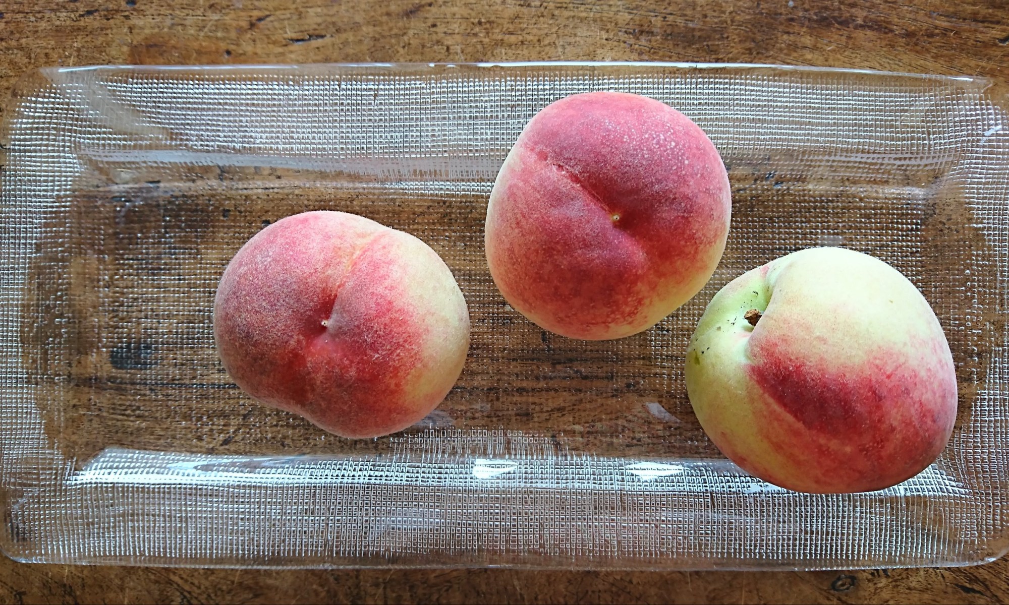 ガラスの器に桃が並んでいます