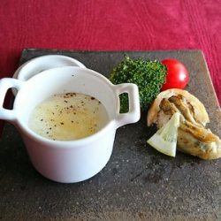 白い小さな器に入ったスープとソテーした牡蠣がお皿の上で並んでいます