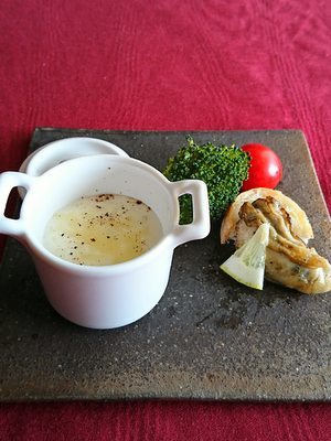 白い小さな器に入ったスープとソテーした牡蠣がお皿の上で並んでいます