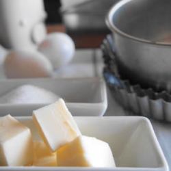 カットされたバターや砂糖、卵と製菓道具が並んでいます