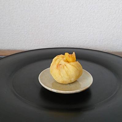 漆黒盆の上に豆皿にのった栗の茶巾しぼりが１つ