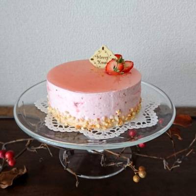 ガラスのケーキスタンドにストロベリームースのホールケーキがあります