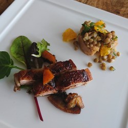 四角い白皿にチキングリルとレンズ豆＆オレンジのサラダが盛り付けられています