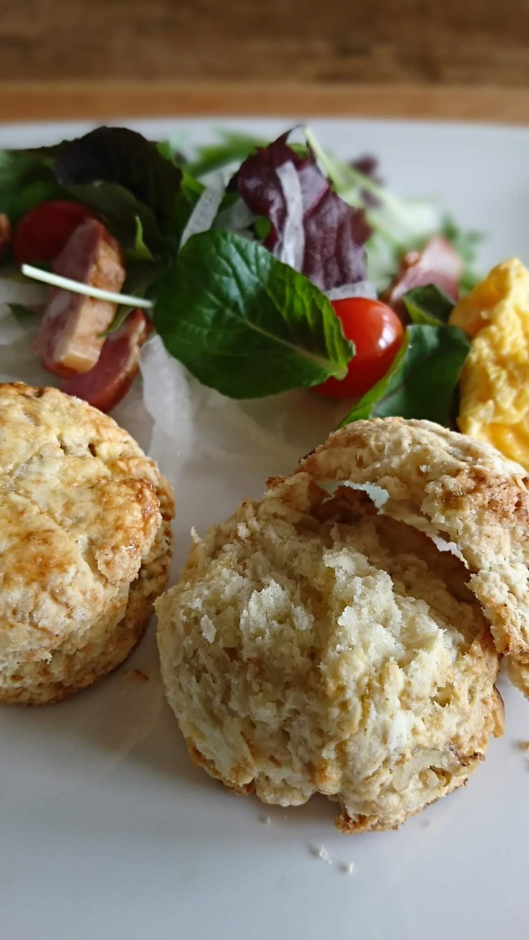 お皿の上に上下に割ったスコーンとサラダが盛り付けられています