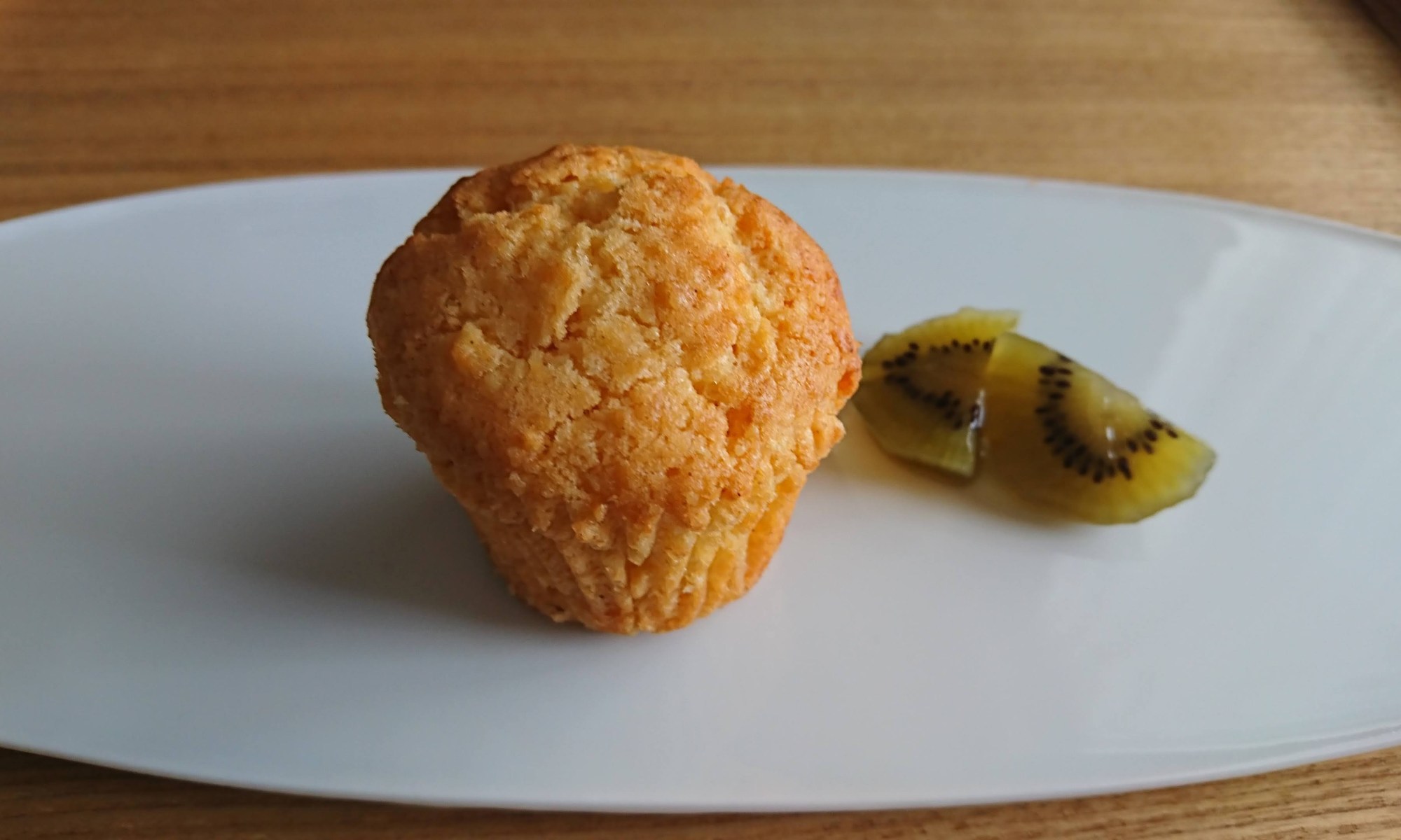 白皿の上にカップケーキとキウイフルーツのビネガー漬けが盛り付けられてます