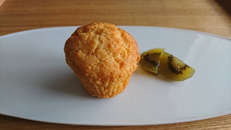 白皿の上にカップケーキとキウイフルーツのビネガー漬けが盛り付けられてます