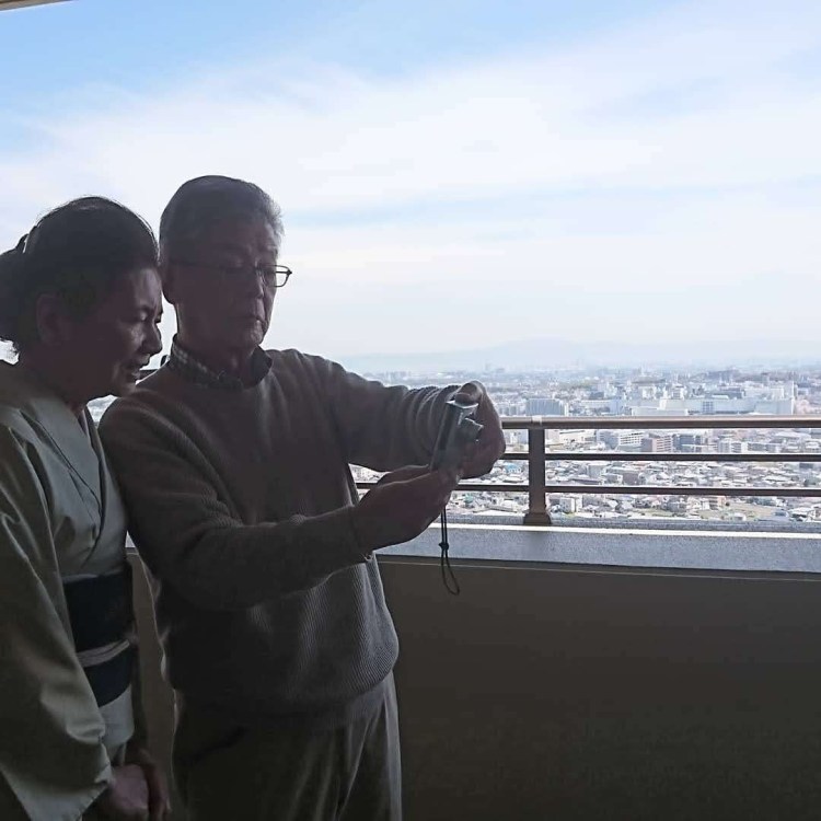 大きな青空と共にベランダで母と寄り添う父