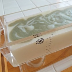 透明な四角い石鹸型に石鹸液を流し込まれた状態