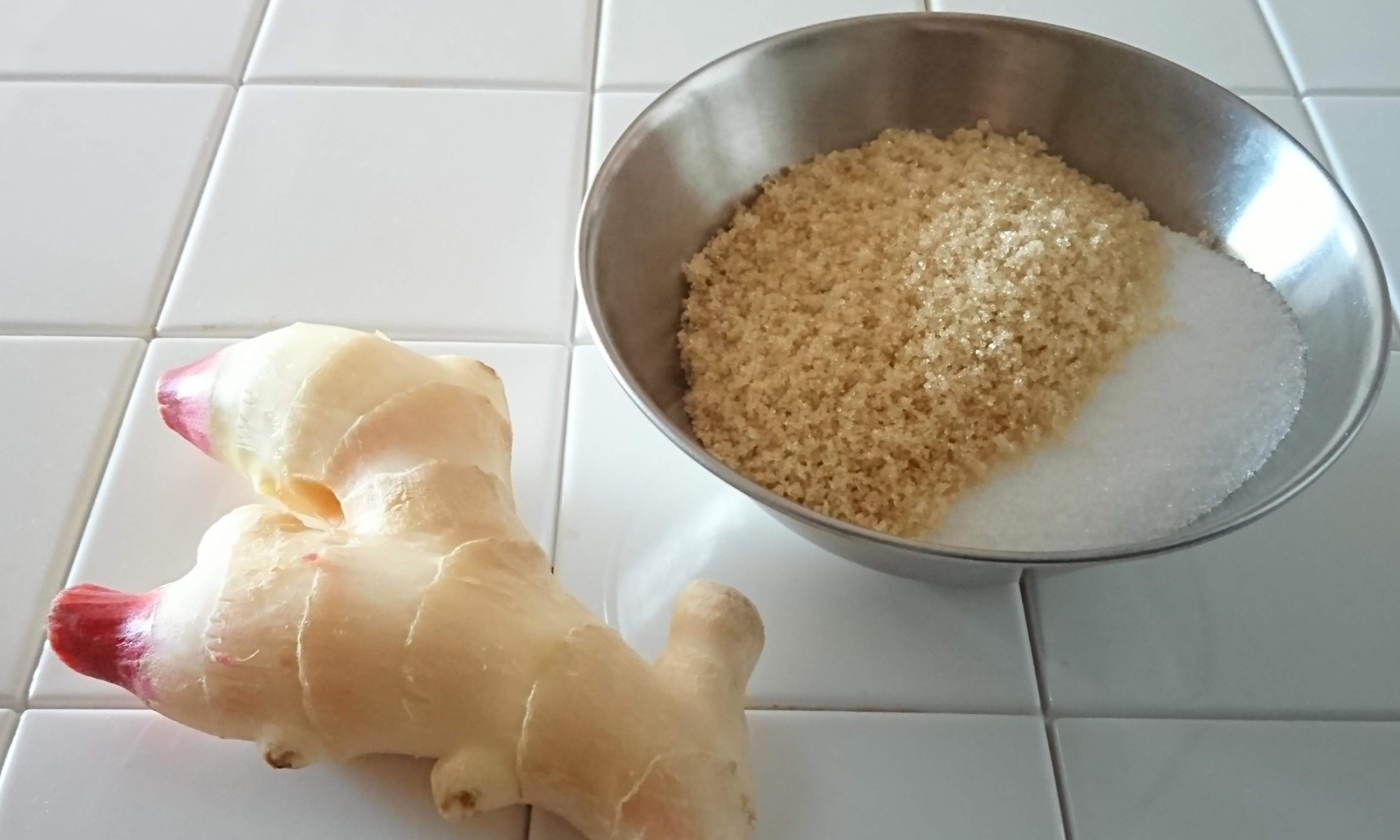 白タイルカウンターの上に新生姜と砂糖が並んでいます。