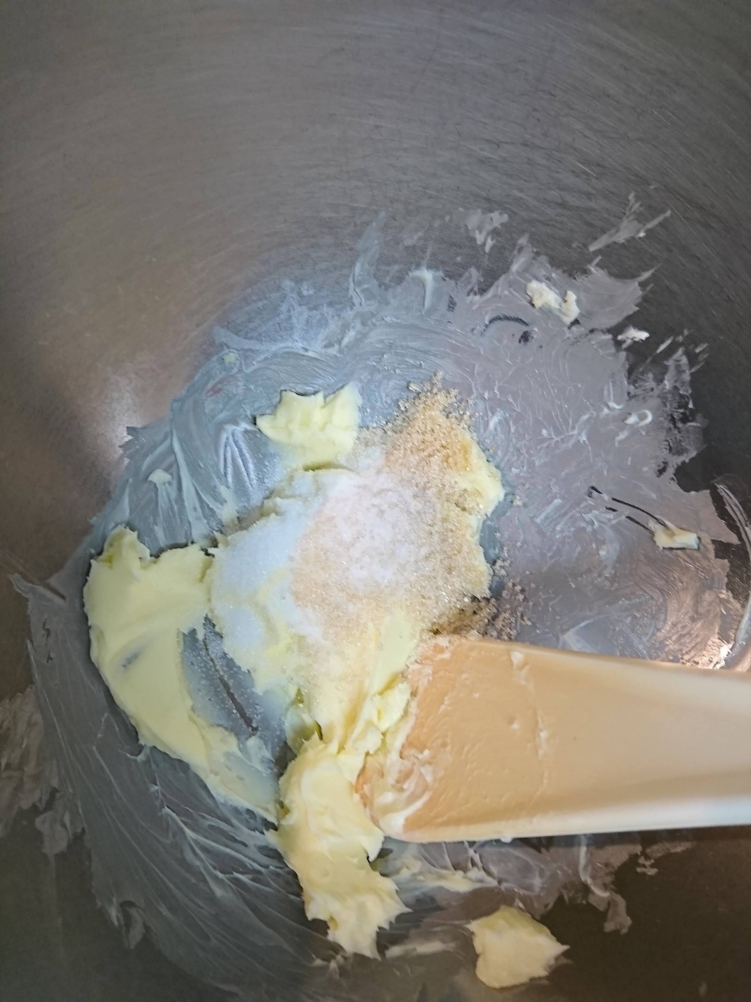 ボウルにバターと砂糖が入り木ベラで混ぜています。