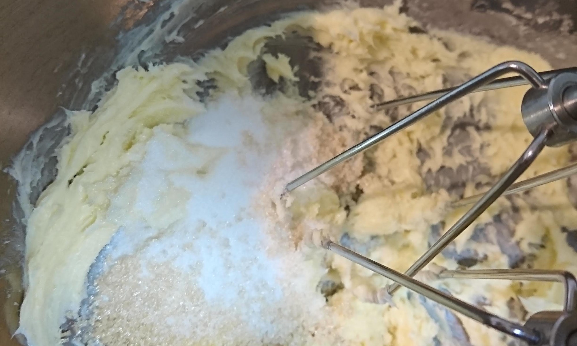 ボウルに練ったバターと砂糖が入りハンドミキサーで混ぜています。