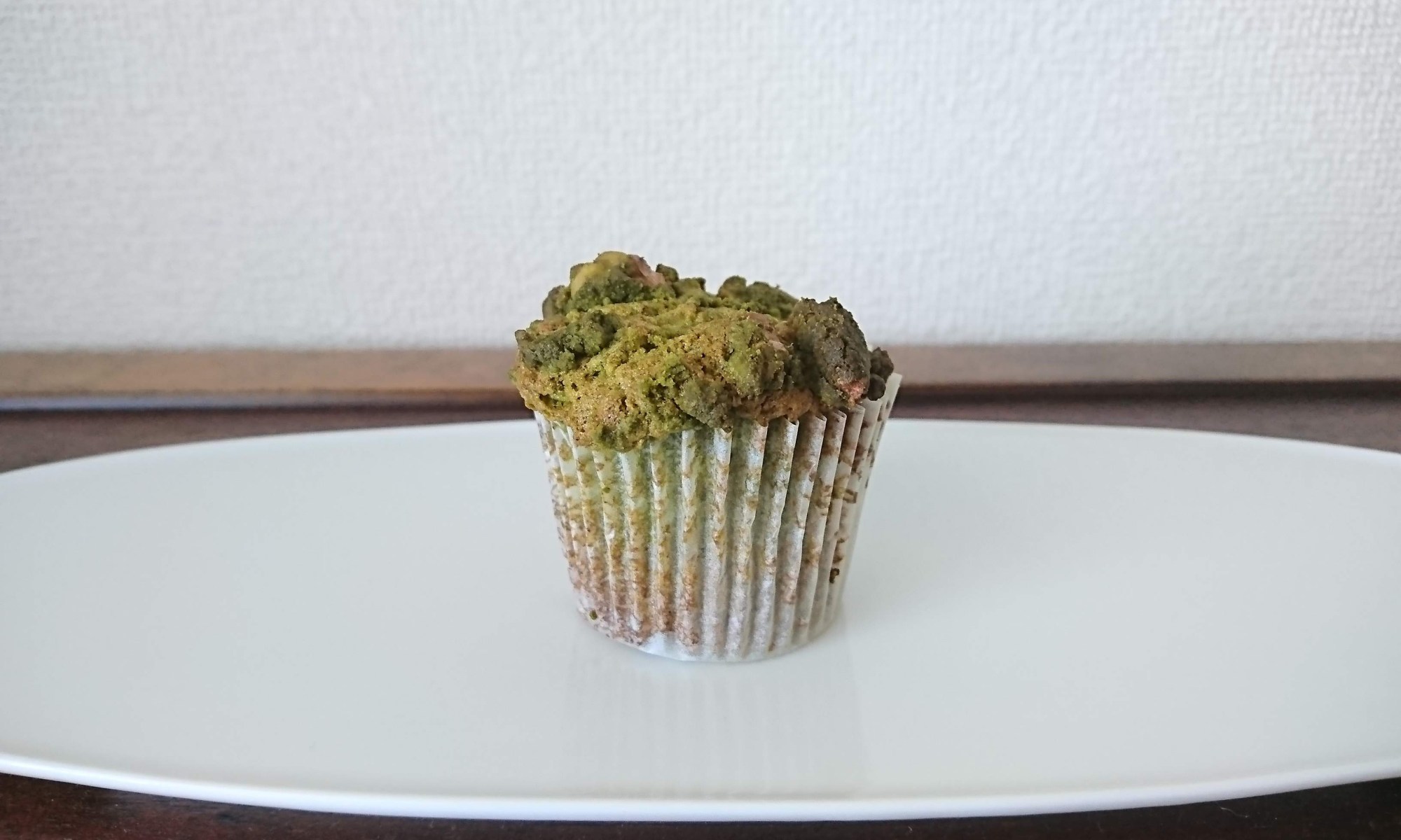 焼き上がったカップケーキが白皿の上に１つ。