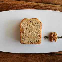 白皿の上にカットされたパウンドケーキと胡桃と茶葉が盛り付けられている