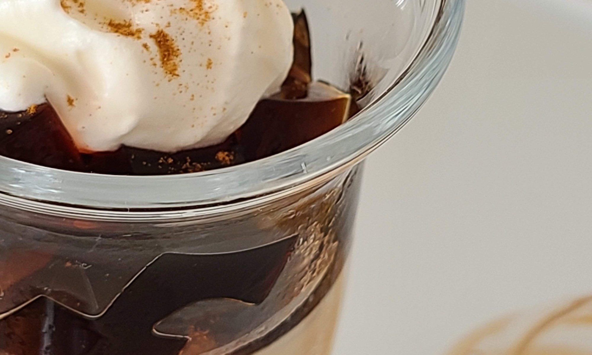 グラスに入った珈琲ブランマンジェの上に珈琲ゼリーとクリームがトッピング