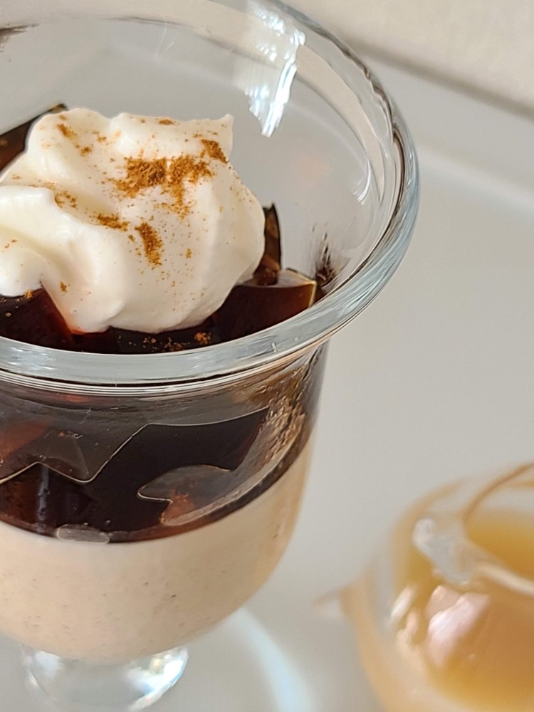 グラスに入った珈琲ブランマンジェの上に珈琲ゼリーとクリームがトッピング