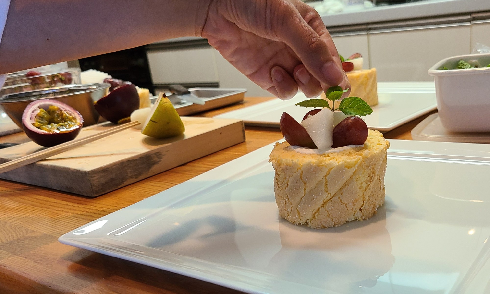 ロールケーキにデコレーション仕上げをしている生徒さんの手元