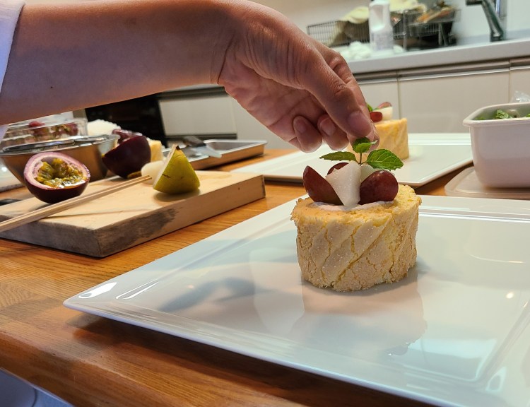 ロールケーキにデコレーション仕上げをしている生徒さんの手元