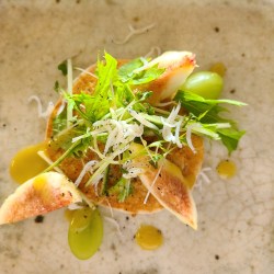 陶器にパンケーキと水菜やしらす、無花果、葡萄が盛り付けられています。