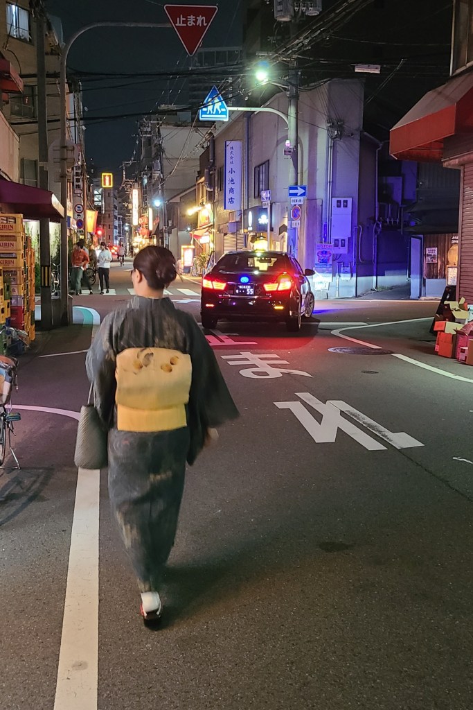 夜の繁華街をあるく着物女子