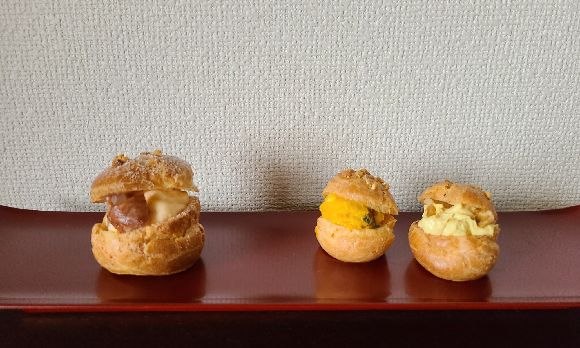 朱漆皿に3つのシュー菓子が並んでいます。