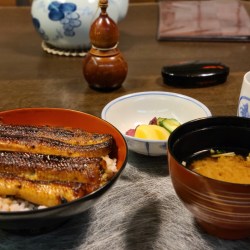 テーブルに鰻丼とみそ汁、漬物が並んでいます。