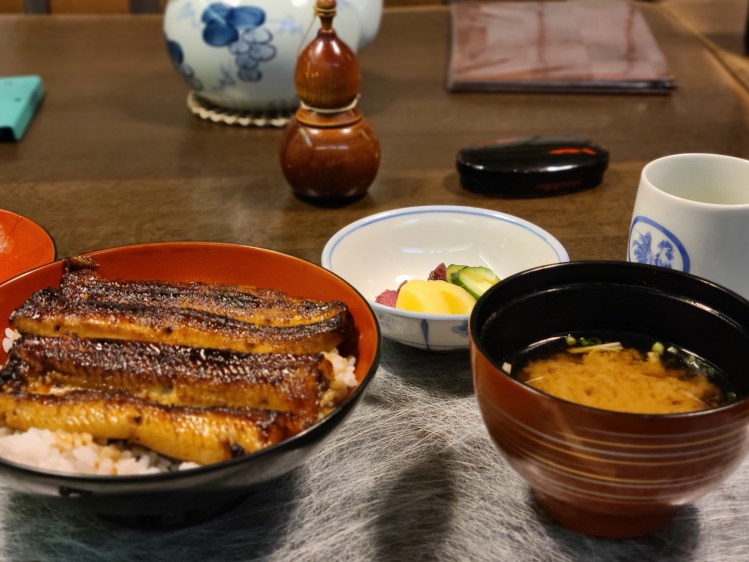 テーブルに鰻丼とみそ汁、漬物が並んでいます。