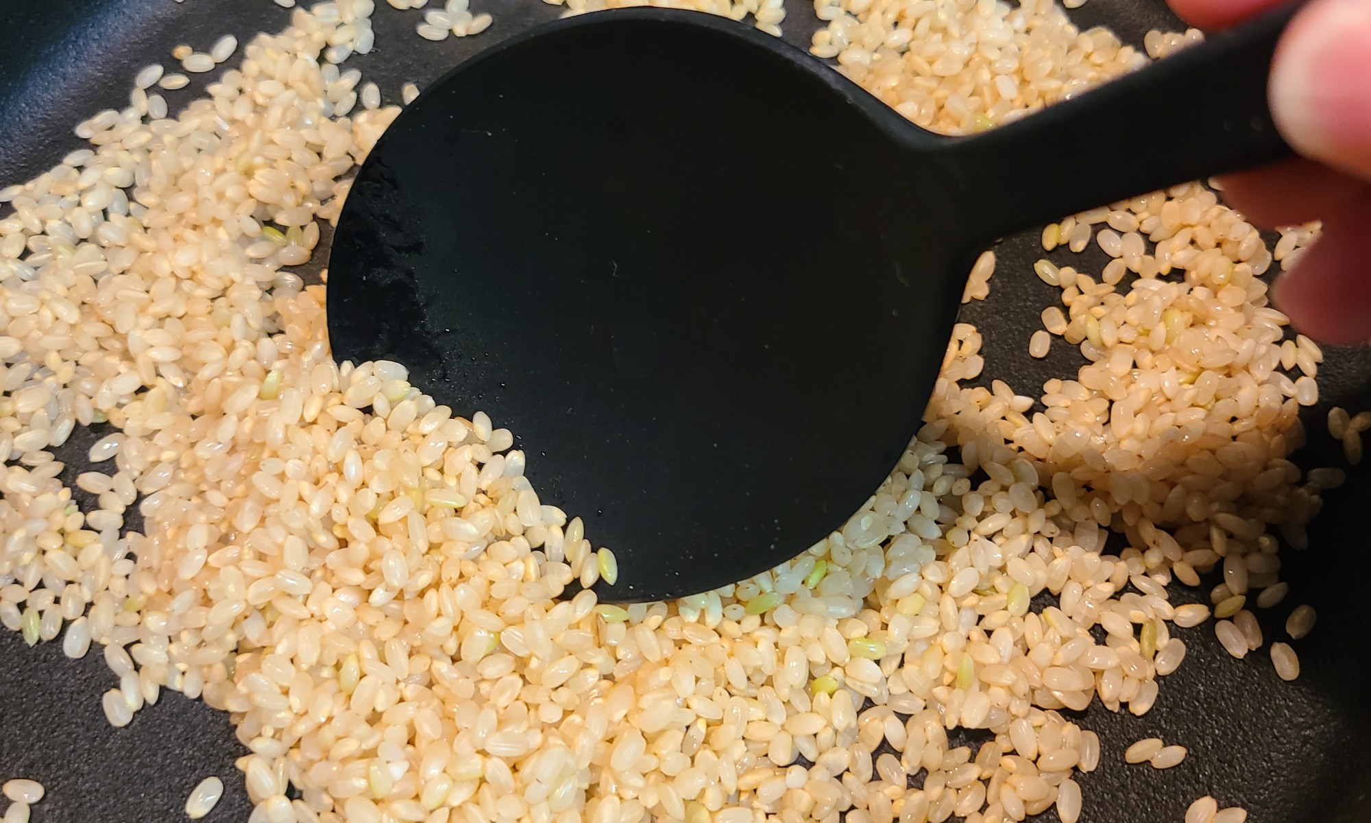 鉄鍋で玄米を炒っている