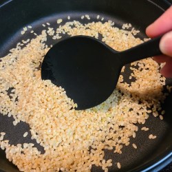 鉄鍋で玄米を炒っている