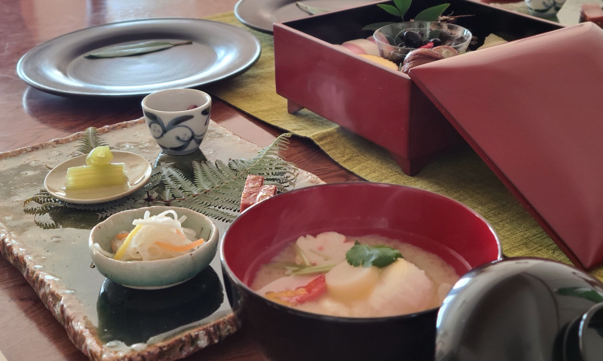 テーブルにお重に入ったお節料理や雑煮などが並んでいます。