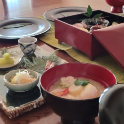 テーブルにお重に入ったお節料理や雑煮などが並んでいます。