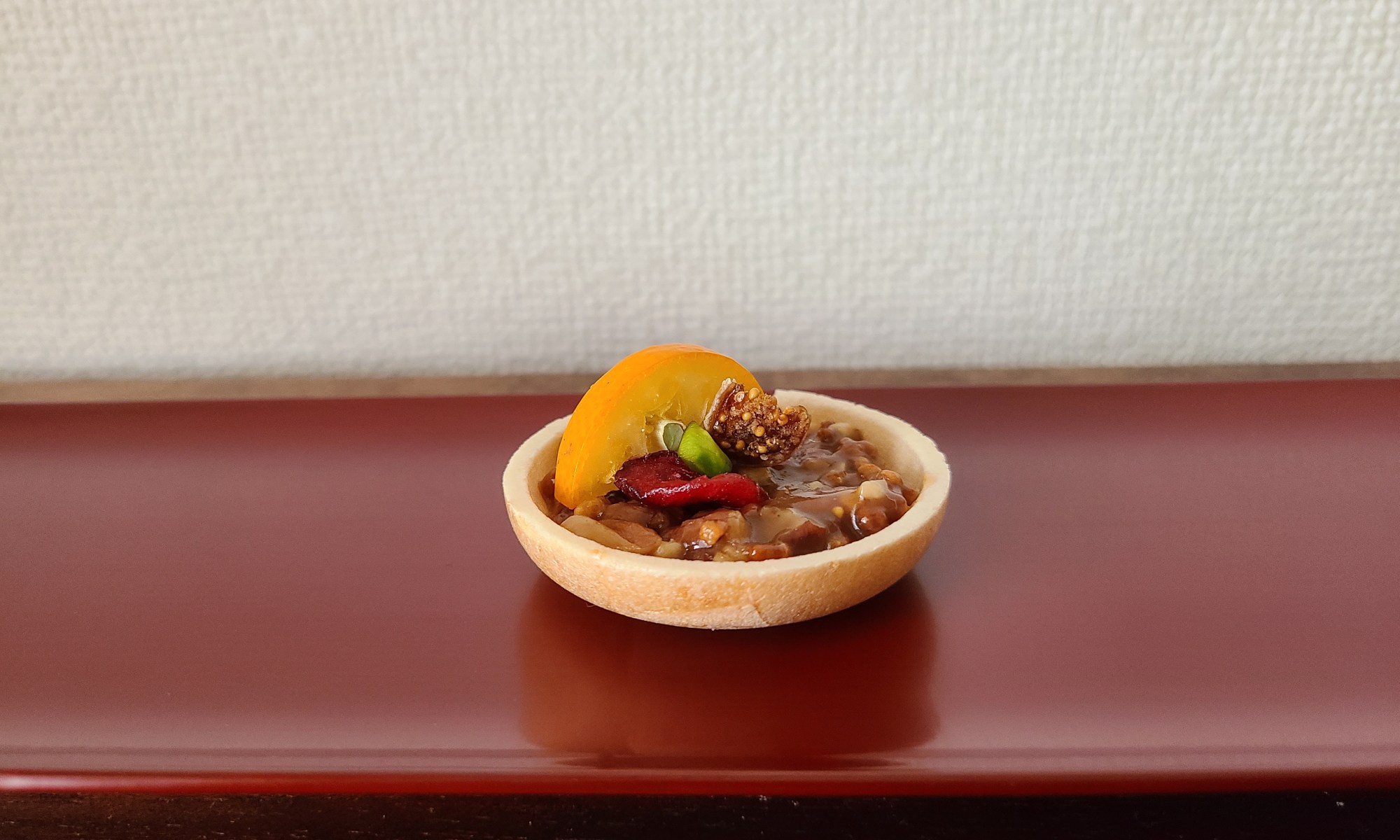 朱漆長皿にフロランタンモナカが１つ。