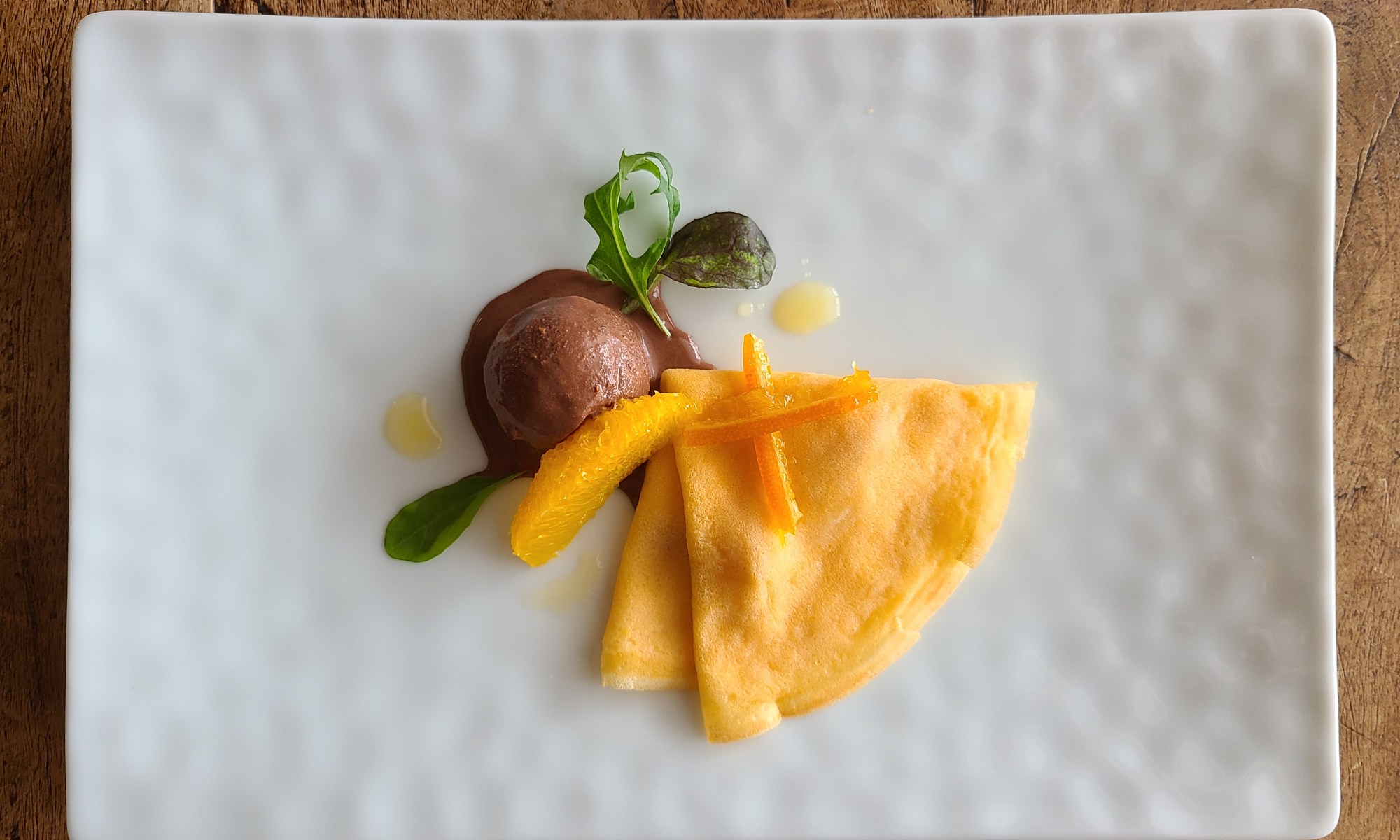 白皿にクレープとショコラソルベ、オレンジピールなどが盛り付けられています。