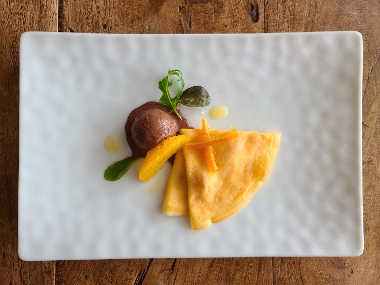 白皿にクレープとショコラソルベ、オレンジピールなどが盛り付けられています。