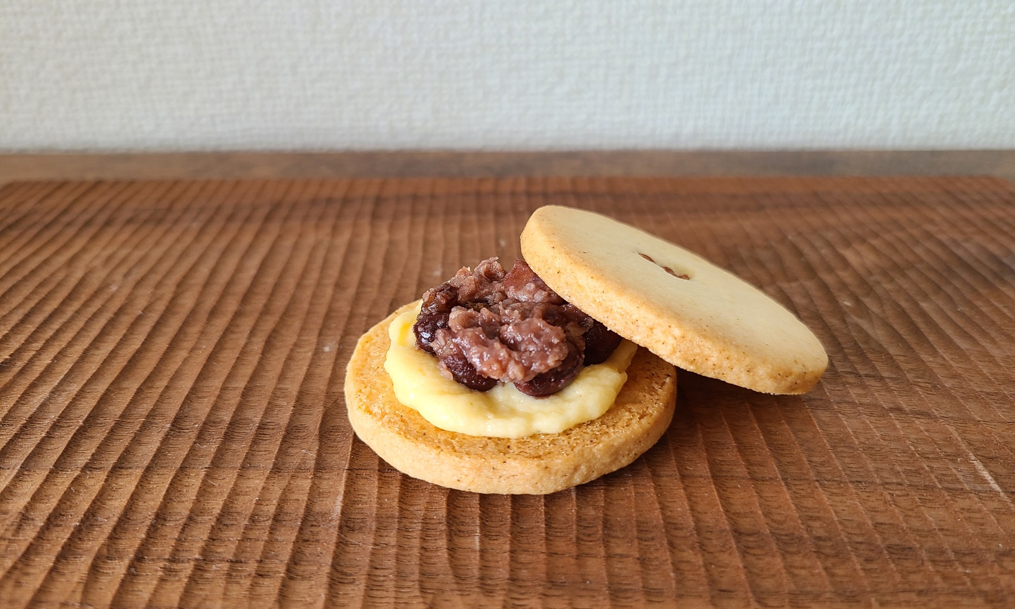 木板の上に発酵小豆とクリームがサンドされたクッキー