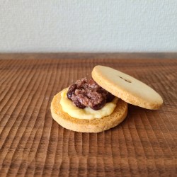 木板の上に発酵小豆とクリームがサンドされたクッキー
