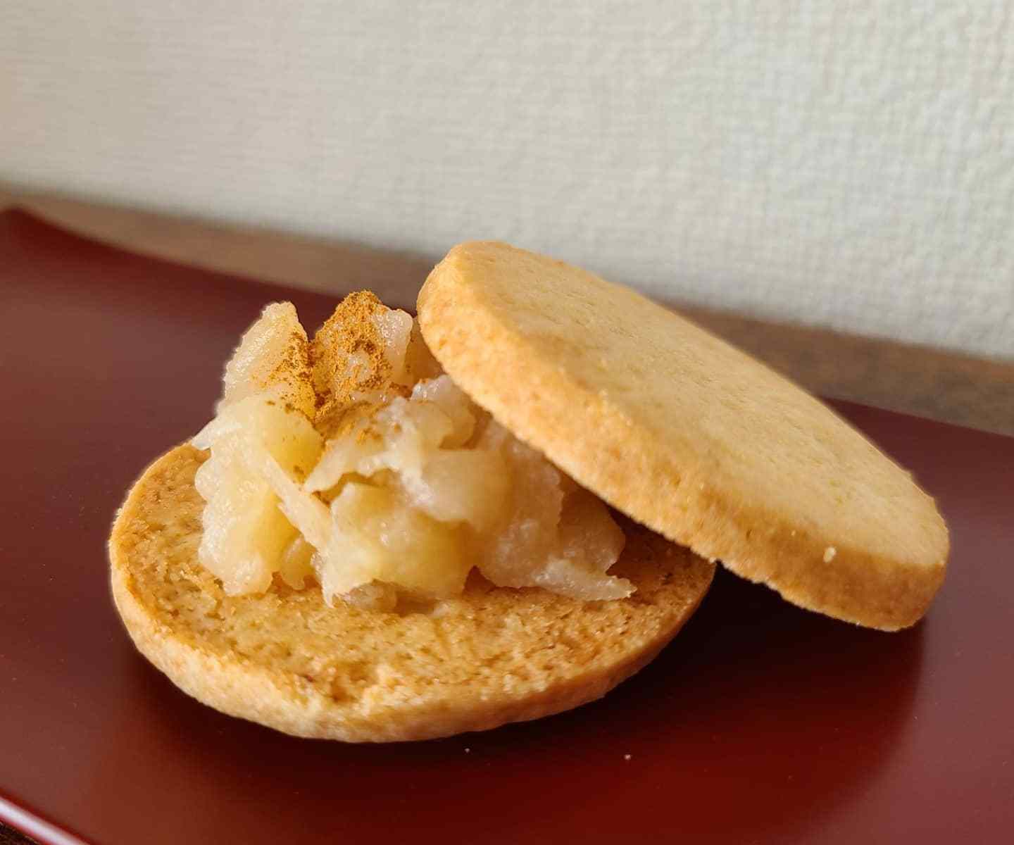 朱色の盆に林檎ジャムが顔をだしたクッキーサンド