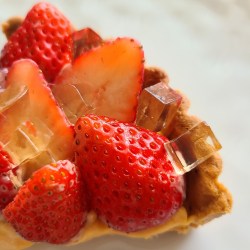 皿にカット苺のタルトが盛り付けられています。