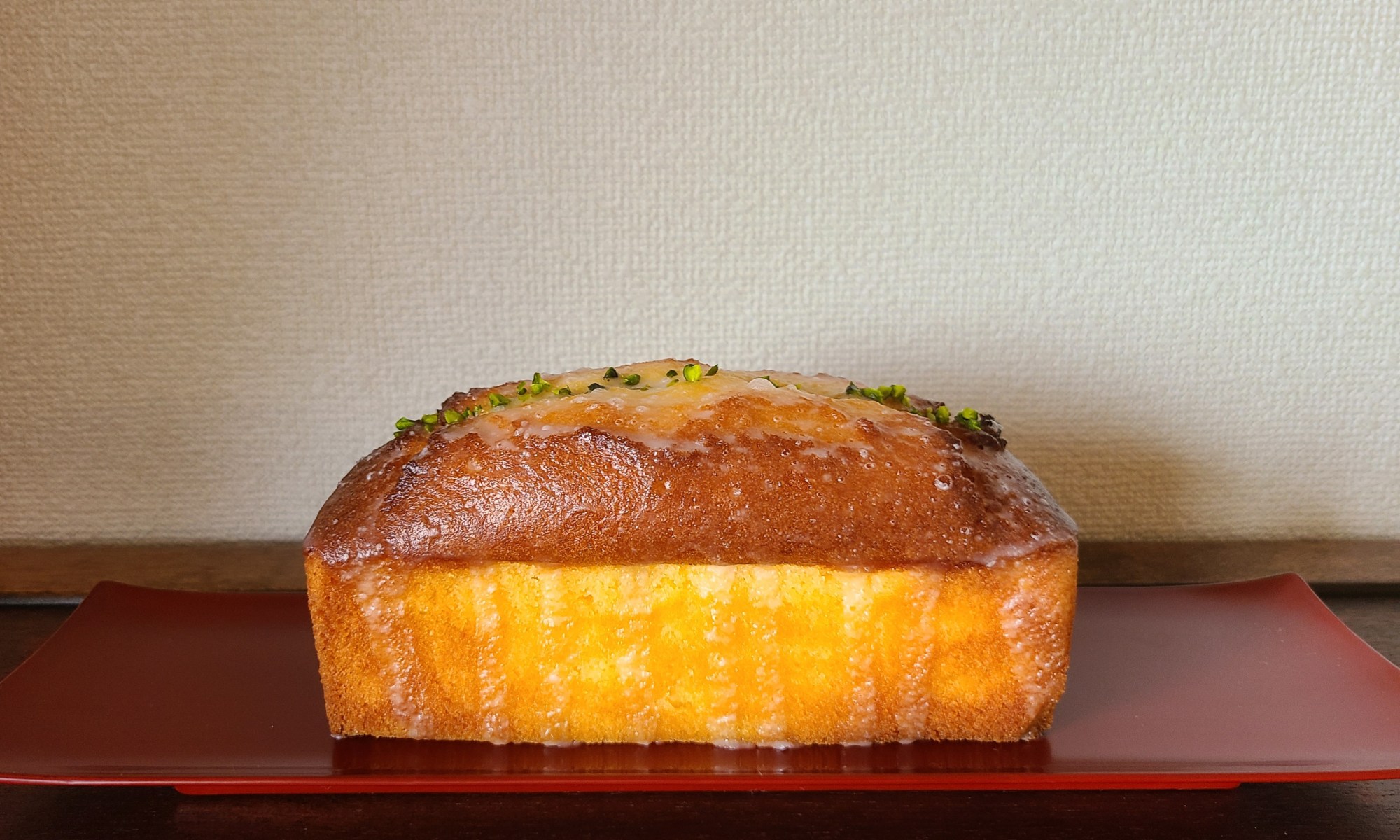 朱色の漆皿の上にパウンドケーキ一本