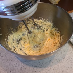 ハンドミキサーを使ってボウルに入った生地を混ぜ合わせている