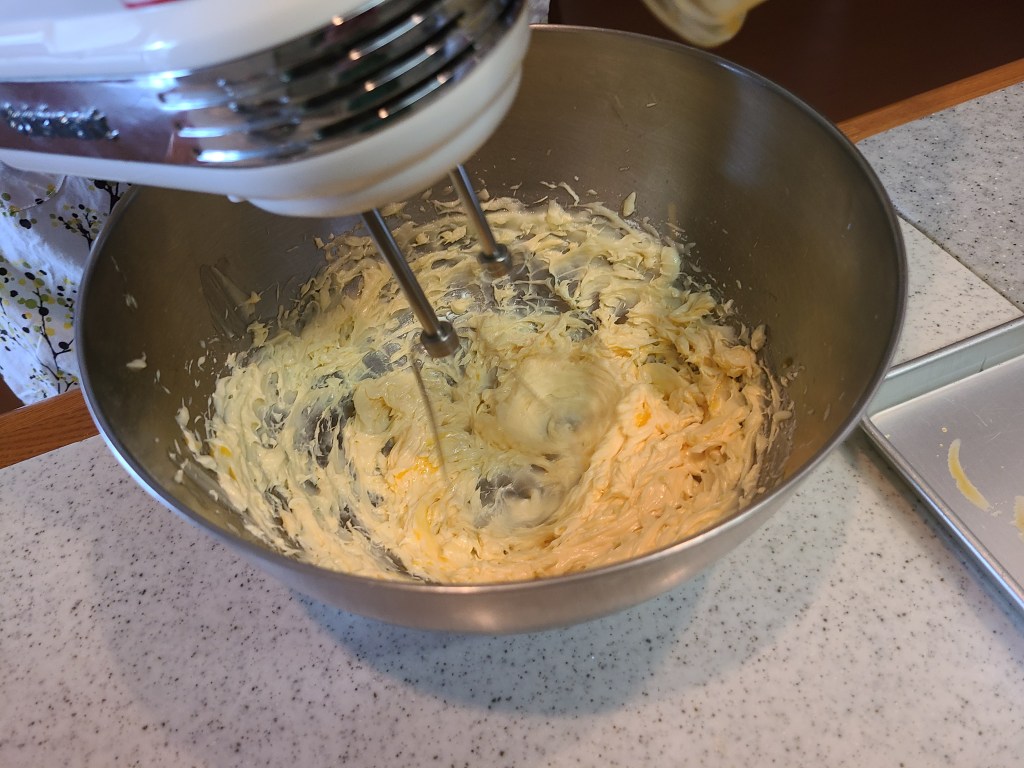 ハンドミキサーを使ってボウルに入った生地を混ぜ合わせている