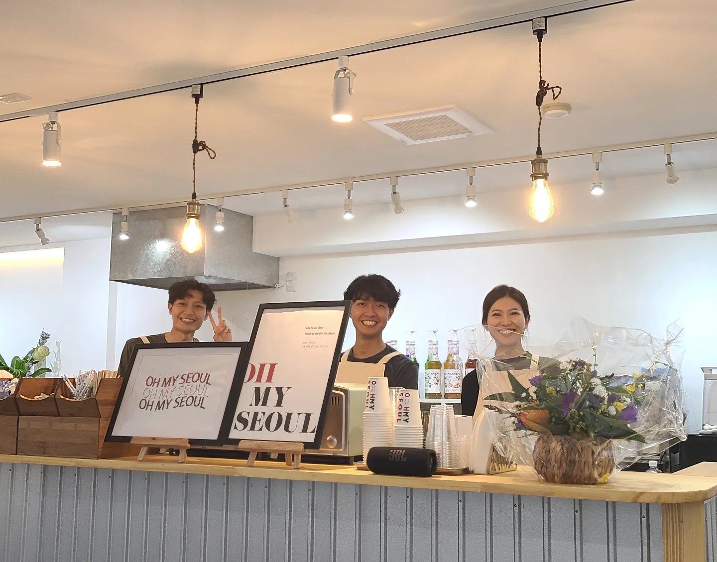 カフェカウンター内に並ぶスタッフ3人