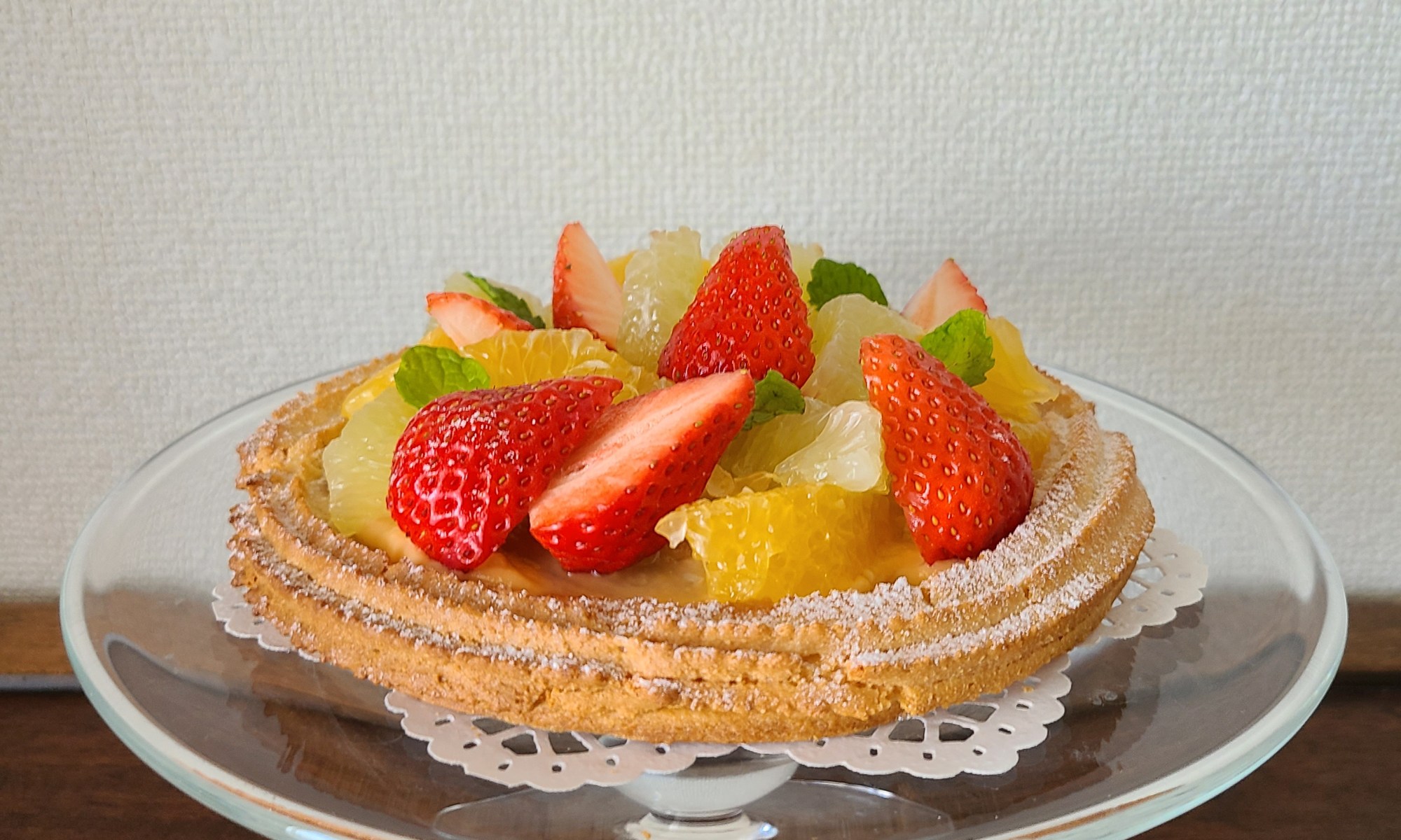 ガラスのケーキスタンドにフルーツタルトがあります