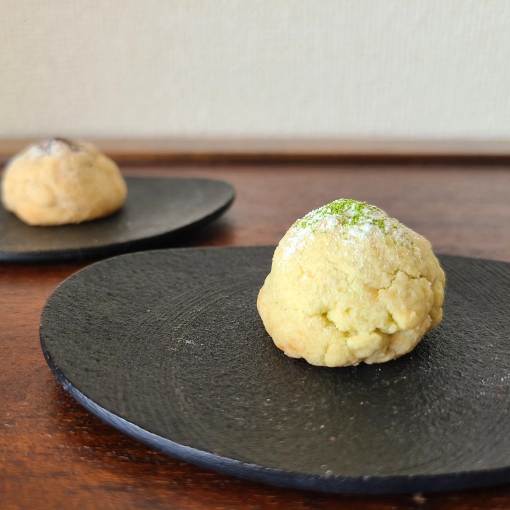 黒皿の上に丸いクッキーが1つ