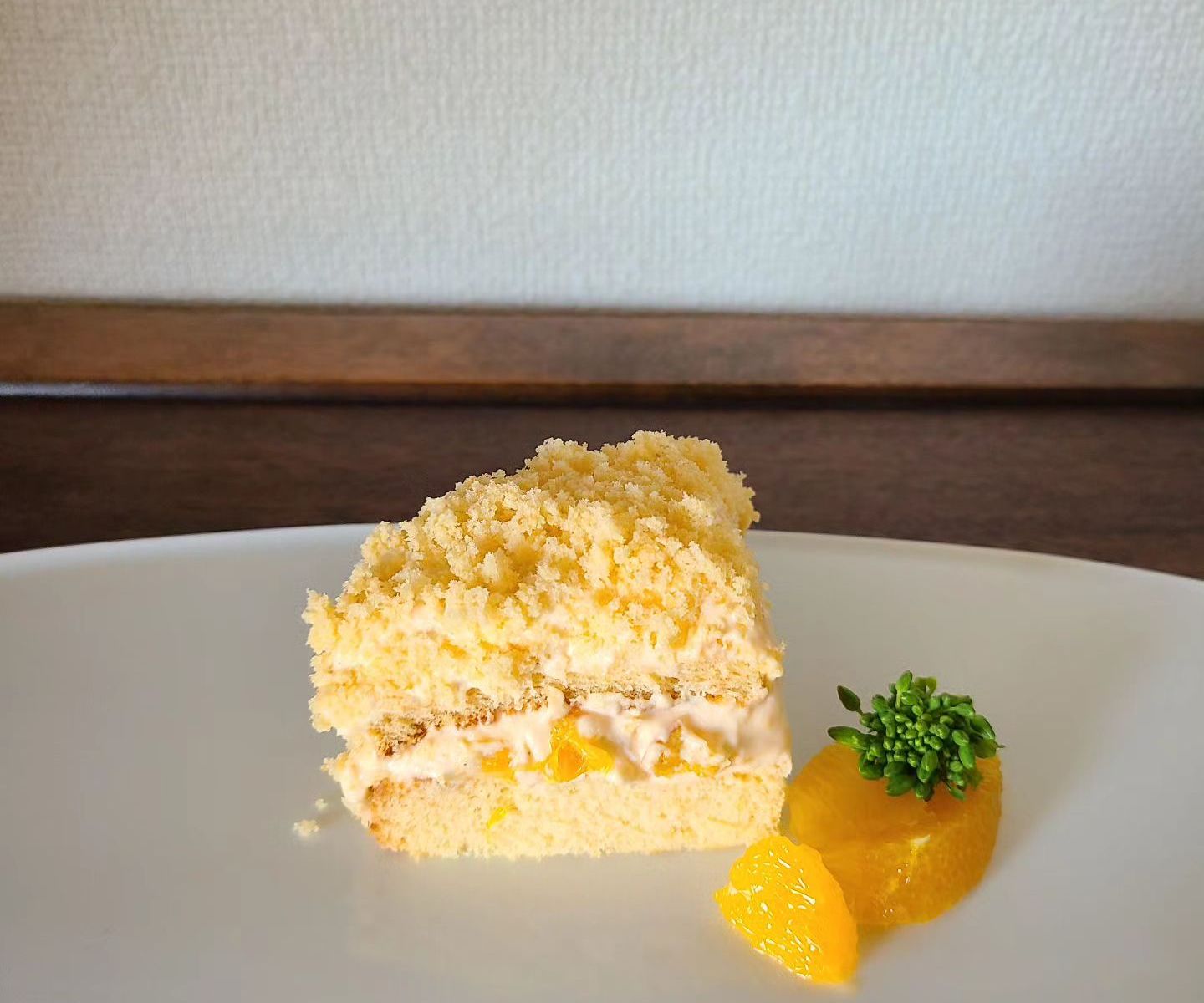 白皿の上にカットしたミモザケーキとオレンジを盛り付け
